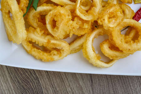 Fried squid rings with lemon, herbs and spices