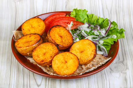 Baked potato - vegetarian barbeque - shashlik served onion rings and tomatoの写真素材