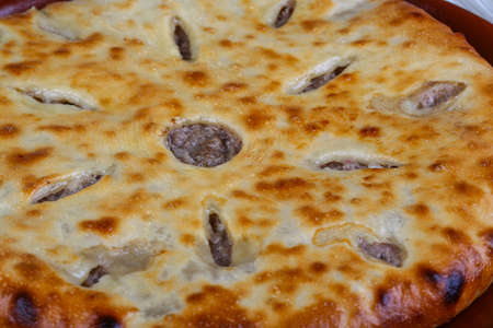 Oriental pastry - fresh hot Ossetian pie in the plate