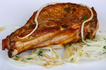 Grilled pork steak with onion rings and herbsの写真素材