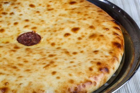 Oriental pastry - fresh hot Ossetian pie in the plate