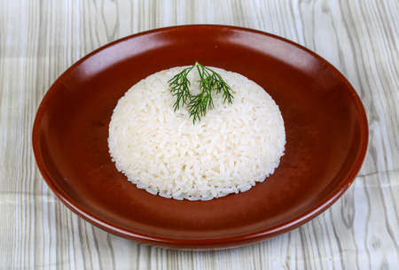 Hot Steamed rice with dill branch on the brown plateの写真素材