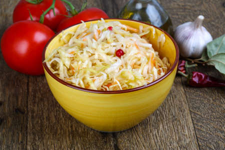 Fermented cabbage - Sauerkraut with herbs and spices on the wood backgroundの写真素材