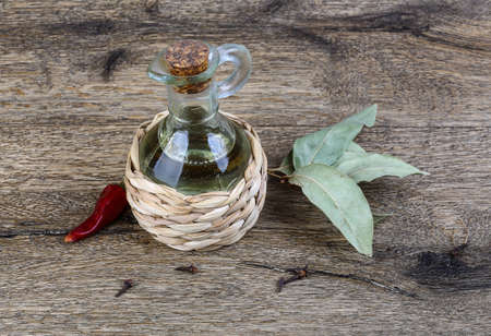 Olive oil with laurel leaves and red pepper on the wood backgroundの写真素材