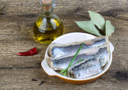 Herring fillet with dill, oil and spices on the wood backgroundの写真素材