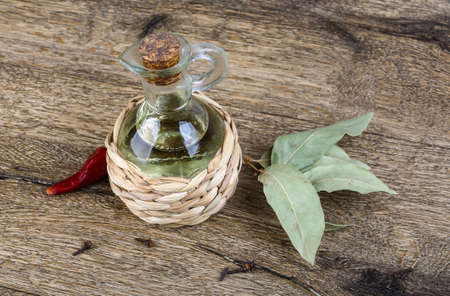 Olive oil with laurel leaves and red pepper on the wood backgroundの写真素材
