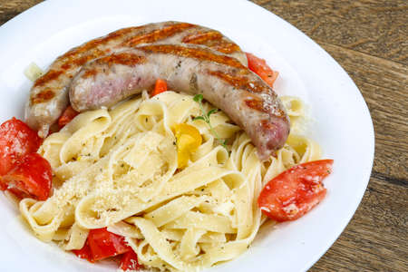 Grilled sausages with pasta on the wood backgroundの写真素材