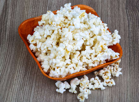 Fresh hot Popcorn in the basket on wood backgroundの写真素材