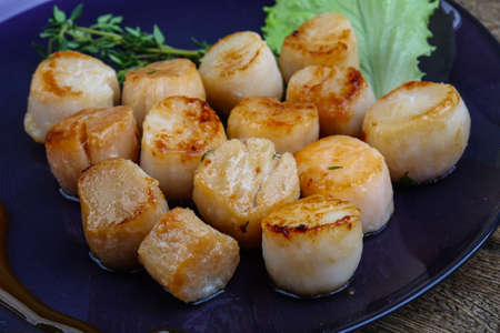 Baked scallops with sauce served salad leaves and thymeの写真素材