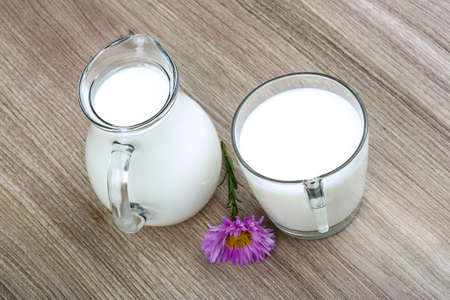 Fresh cold milk in glass on the wood backgroundの写真素材