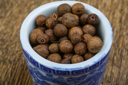 Fresh dry Aroma pepper corns on the wood backgroundの写真素材