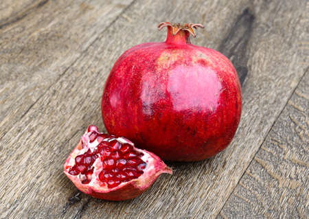 Fresh bright Pomegranate on the wood backgroundの写真素材