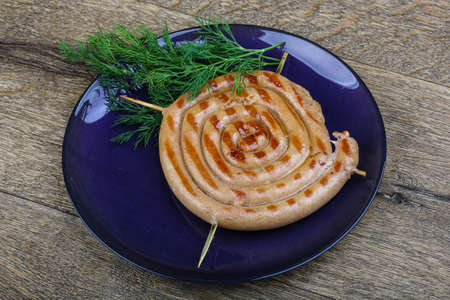 Grilled round sausage with dill branch on woodの写真素材
