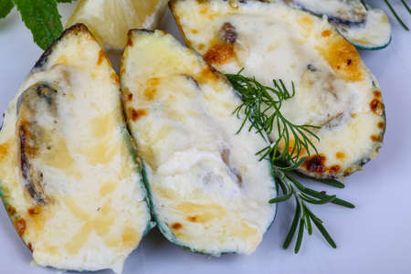 Mussels backed in cream sauce with rosemary on wood backgroundの写真素材