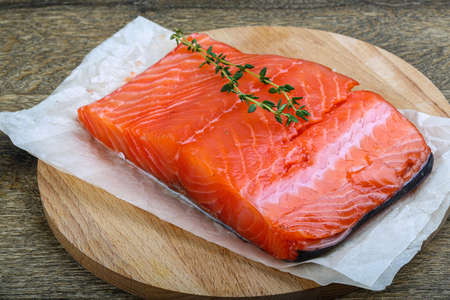 Salmon fillet served fresh thyme branch on woodの写真素材