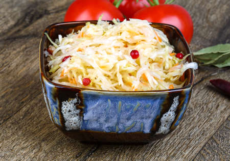 Fermented cabbage - Sauerkraut with herbs and spices on the wood backgroundの写真素材