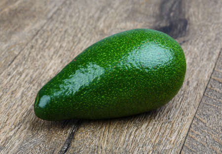 Fresh green ripe avocado on the wood backgroundの写真素材