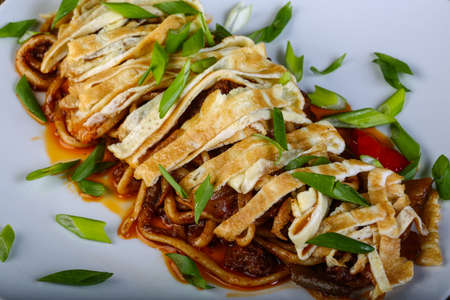 Pasta with omelet and beef served green onion