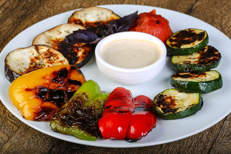 Hot juicy grilled vegetables with white sauceの写真素材