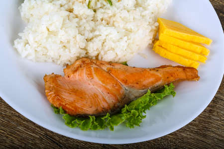 Roasted salmon steak with rice and herbsの写真素材