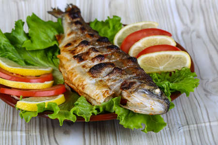 Grilled trout barbeque served lemon, tomato and salad leaves