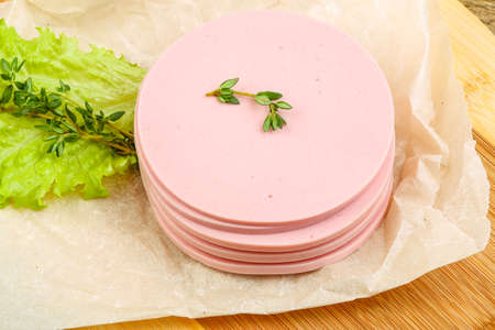 Sliced sausages with salad leaves and thyme on the wood backgroundの写真素材