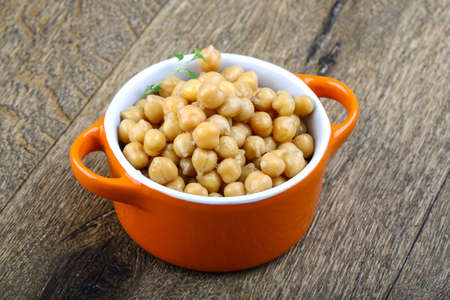 Canned chickpeas in the bowl on wood backgroundの写真素材