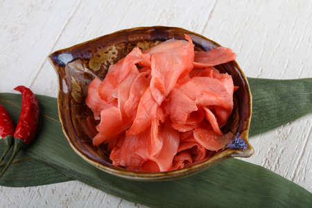 Pickled ginger in the bowl on green leavesの写真素材