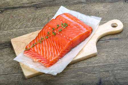 Salmon fillet served fresh thyme branch on woodの写真素材