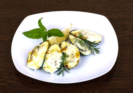 Mussels backed in cream sauce with rosemary on wood backgroundの写真素材