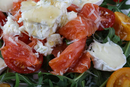 Salad with salmon, tomato, rucola and cheese