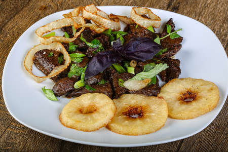 Grilled liver with onion rings and herbsの写真素材