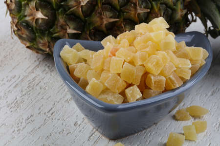 Dried pineapple in the bowl on wood backgroundの写真素材