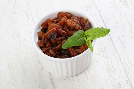Raisin in the bowl on the wood backgroundの写真素材