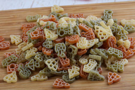 Raw pasta symbols for kids on wood