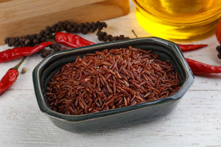 Raw Brown rice in the bowl on wood backgroundの写真素材