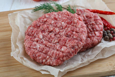 Raw burger cutlet with spices ready for cookingの写真素材