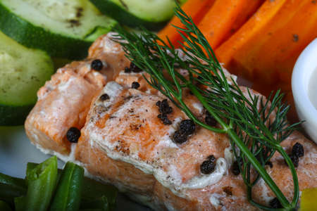 Baked salmon with vegetables and white sauceの写真素材