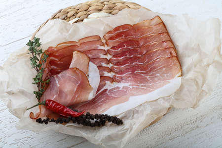 Sliced jamon with thyme on wood backgroundの写真素材