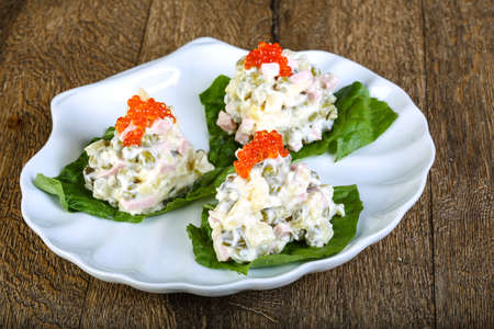 Russian salad with red caviar on wood backgroundの写真素材