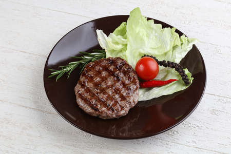 Grilled burger cutlet with rosemary and salad leavesの写真素材