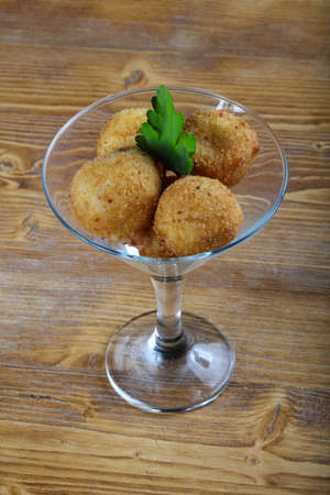 Cheese balls with parsley leaves on the wood backgroundの写真素材