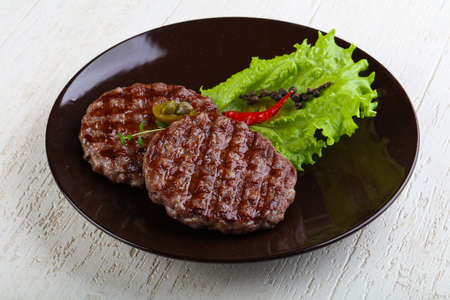 Grilled burger cutlet with salad leaves