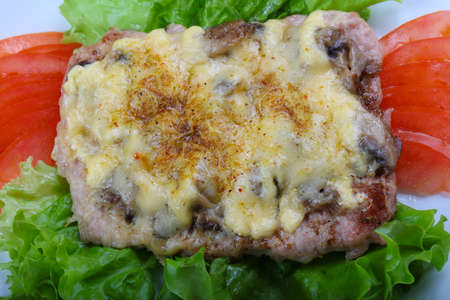 Pork steak with mushroom and cheese served tomatoの写真素材