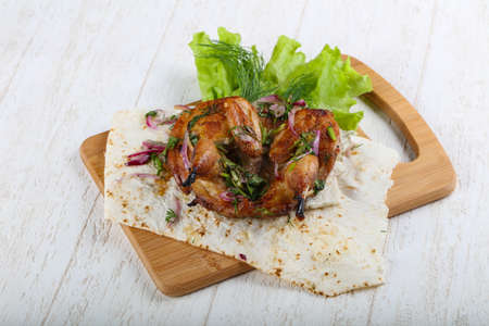 Grilled quail with onion and salad leavesの写真素材