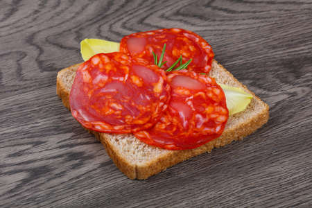 Chorizo sandwich with salad leaves on wood backgroundの写真素材