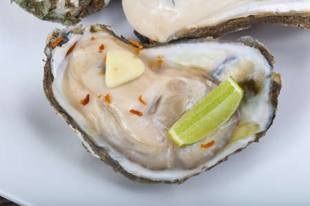 Raw oysters with lime and sliced garlikの写真素材