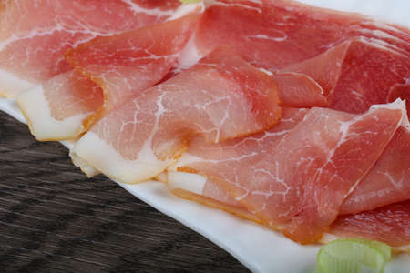 Spanish jamon on the wood background and onion