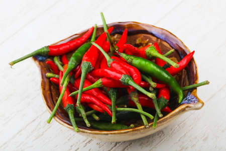 Hot chili pepper heap on the wood backgroundの写真素材