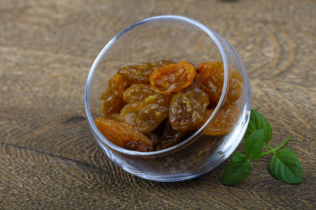 Sweet raisins in the bowl with mint leavesの写真素材